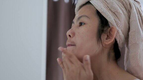 亚洲女性在脸上涂润肤霜