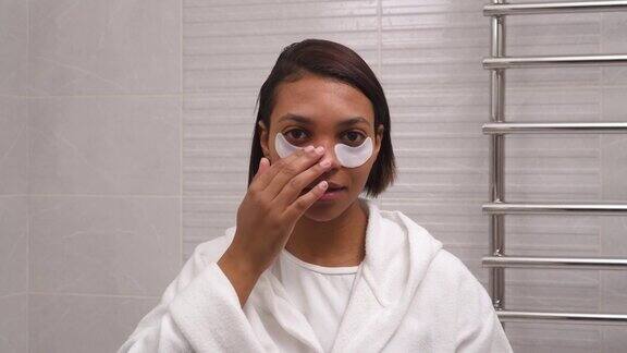 年轻美丽的女子用白色眼罩抗皱皮肤水合作用