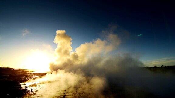 冰岛间歇泉喷发冬天的冷色阳光透过蒸汽照射