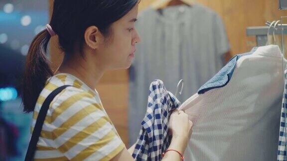 年轻的亚洲妇女在商店买了一块布