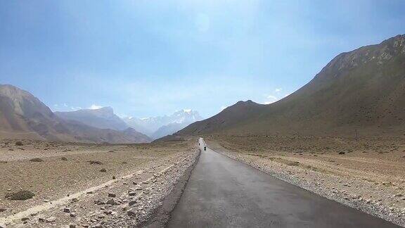 骑摩托车的人在山区的路上行驶