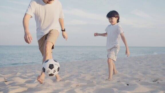 父亲在教儿子在海滩上踢足球
