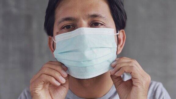 亚洲青年男子戴卫生口罩预防感染covid-19