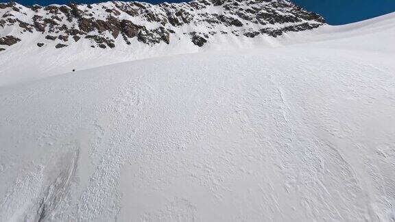 高山冰川雪冬季山谷阳光悬崖山顶景观滑雪者爬上斜坡鸟瞰