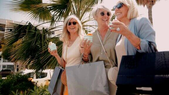 成熟的女人在城市里购物和吃冰淇淋