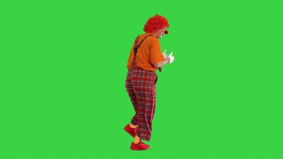 快乐的小丑在绿色屏幕上行走时竖起大拇指颜色键