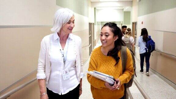 少女与高中老师在学校走廊谈话