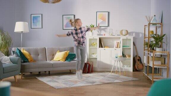 可爱的快乐女孩在客厅中间跳舞快乐的孩子独自在家跳舞