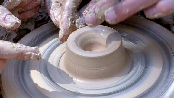 陶工的手在陶工轮上用粘土制作陶器
