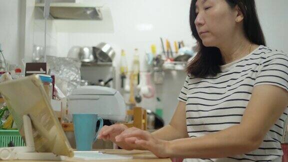 亚洲成年妇女在新冠肺炎期间在家厨房工作隔离生活方式概念
