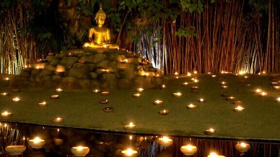 佛像在蜡烛的环绕下冥想