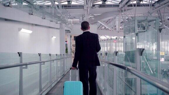 提着蓝色行李箱的商人到机场办理登机手续