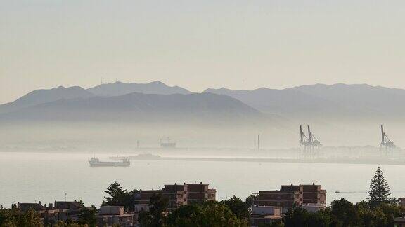 时间流逝在马拉加港口的日落伴随着潮湿和小船航行造成的薄雾