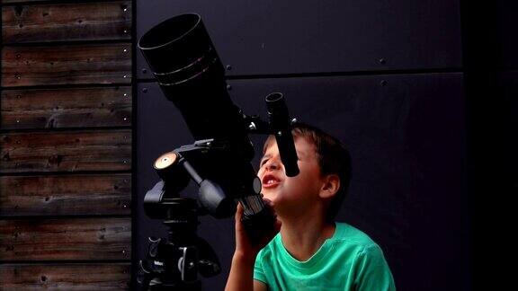 小男孩用望远镜观察天空