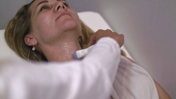 正在用超声波检查甲状腺的妇女