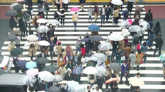 日本东京新宿商业区日本人挤在新宿JR车站大楼之间的街道上的4K镜头