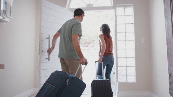 带着行李的家人打开前门准备去度假