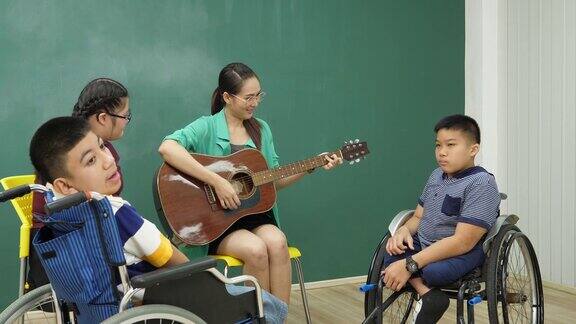 老师在教室里陪着残疾儿童弹吉他