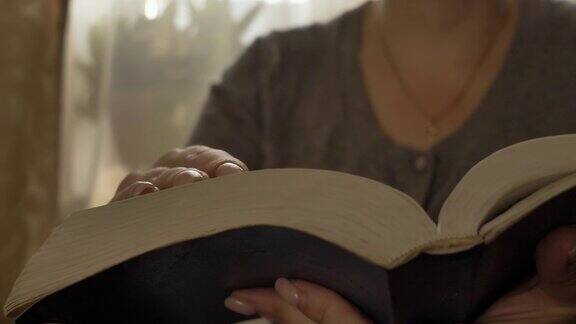 女人翻着一本书翻开圣经合上