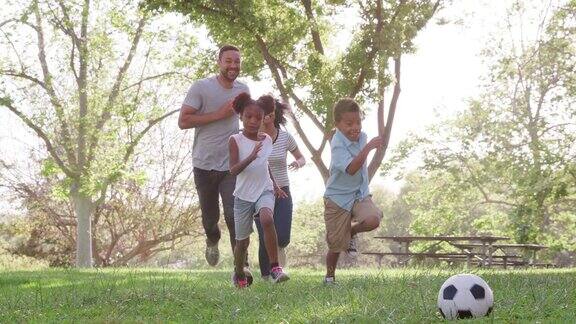全家一起在公园踢足球的慢动作镜头