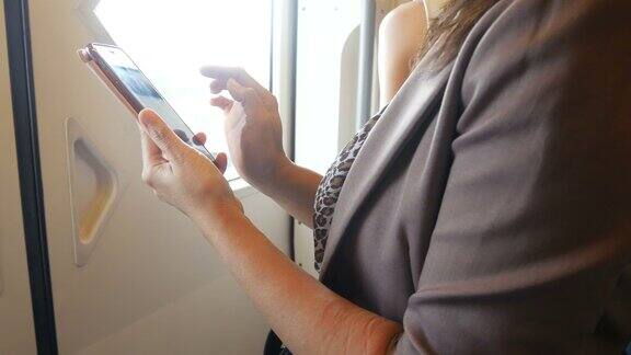 商务女性在城市火车上使用智能手机