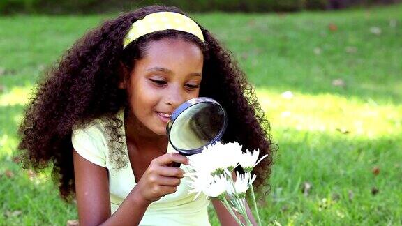 小女孩坐在草地上看花