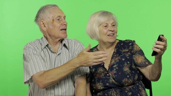 一名老年男子和一名女性正在用智能手机进行视频聊天色度键