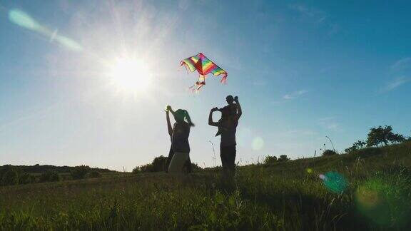 快乐的家庭在一个阳光明媚的日子里在草地上玩风筝