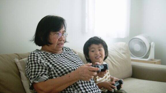 兴奋的男孩在家里和奶奶玩电子游戏