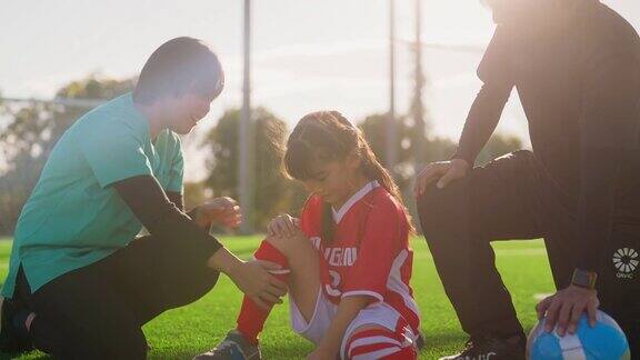 护士检查小学女生足球或足球运动员的伤势
