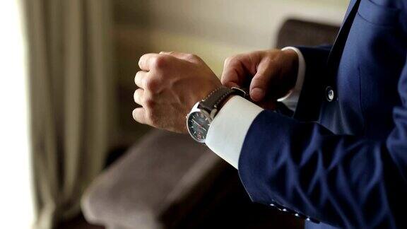 一个优雅的男人把一个时钟放在手上特写