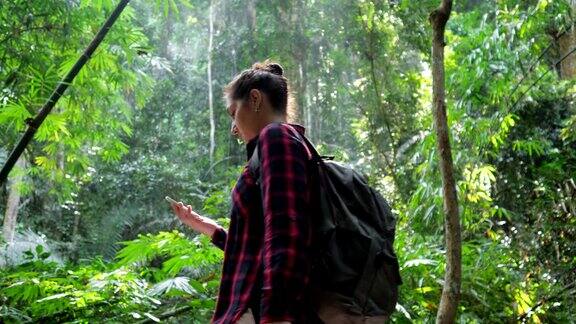 郁郁葱葱的热带雨林和背包女通过相机