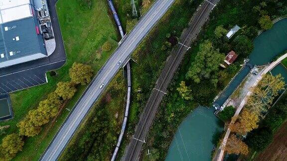 鸟瞰图火车载着商品通过一座桥铁路旁边的一条河