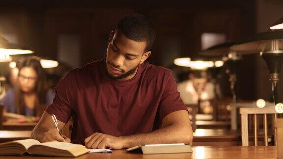 一个年轻的非裔美国人在图书馆学习