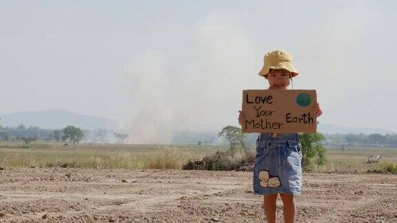 小女孩拿着“爱你的地球母亲”海报上面写着抗议空气污染的标语世界环境日全球变暖