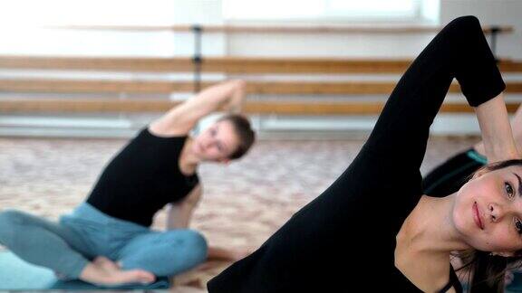 一群女性在健身房里做瑜伽伸展运动