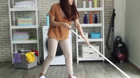 女清洁工在家用拖把打扫房间