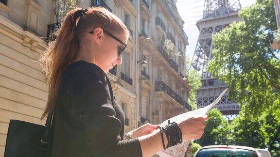 游客拿着巴黎地图站在一条小巷里看埃菲尔铁塔