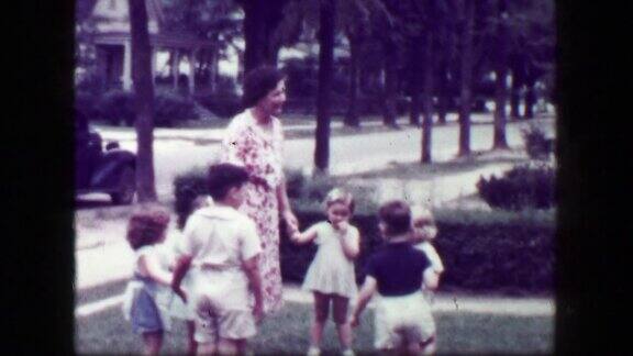 1949年:一位女教师牵着孩子们的手在前院玩