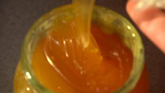 新鲜的蜂蜜正被倒入一个罐子里特写镜头