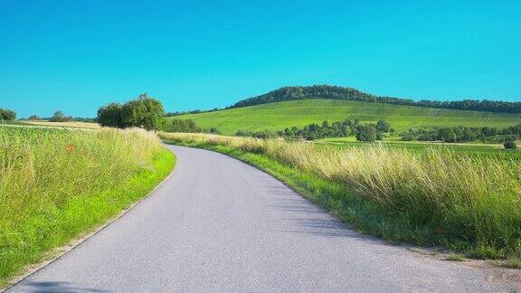 一条穿过草地的狭窄道路后面是群山