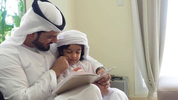 阿拉伯爸爸和儿子在家里看书做作业
