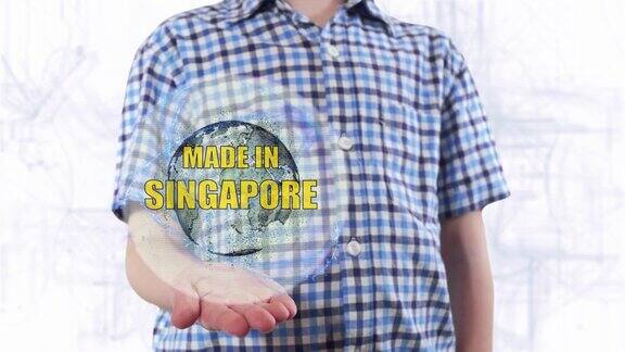 一个年轻人展示了地球的全息图上面写着“新加坡制造”