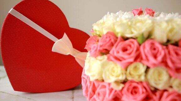 一束粉红色和白色的玫瑰盒子里有一个心形的礼物