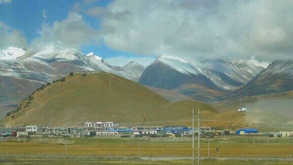 在西藏平原的村庄后面有雪景如画的喜马拉雅