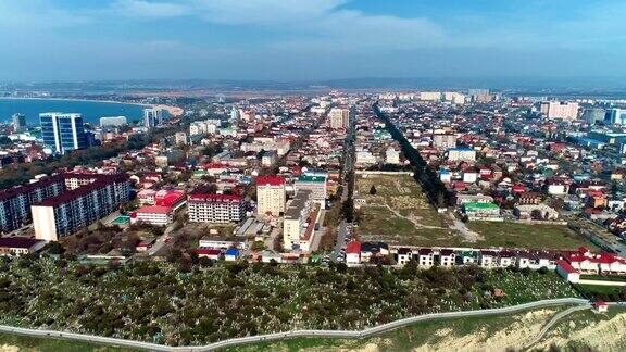 在阳光明媚的日子里在俄罗斯沿海城市阿纳帕上空飞行城市和海湾的鸟瞰图