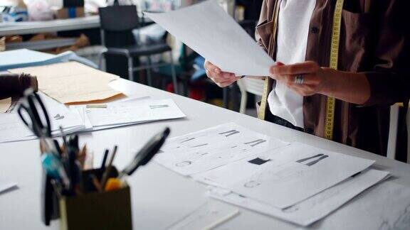 服装设计师拿着衣服的图纸在工作室创作服装