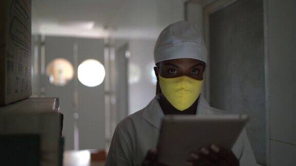 一名员工戴着口罩使用数字平板电脑