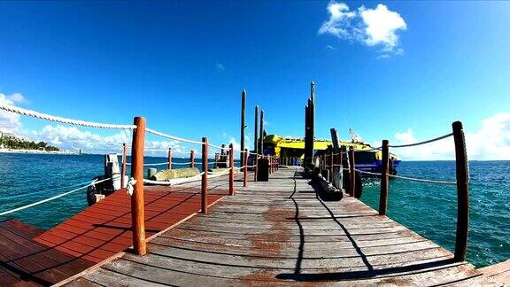 慢镜头:加勒比海海滩上的木制码头和渔船