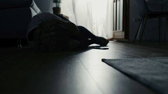一名女子躺在地板上头部被疼痛掩盖